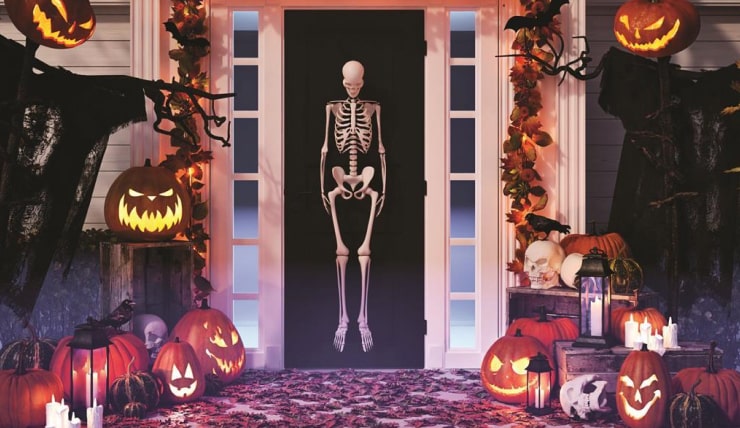 Spooky DIY decor for Halloween party with skeleton, scarecrow and Jack-o'-lanterns.