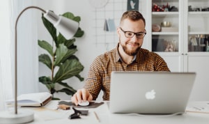 Graphic designer earning money with Lulu.com on his Mac.